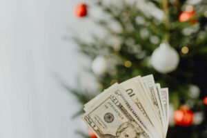 bunch of banknotes with a christmas tree in a background